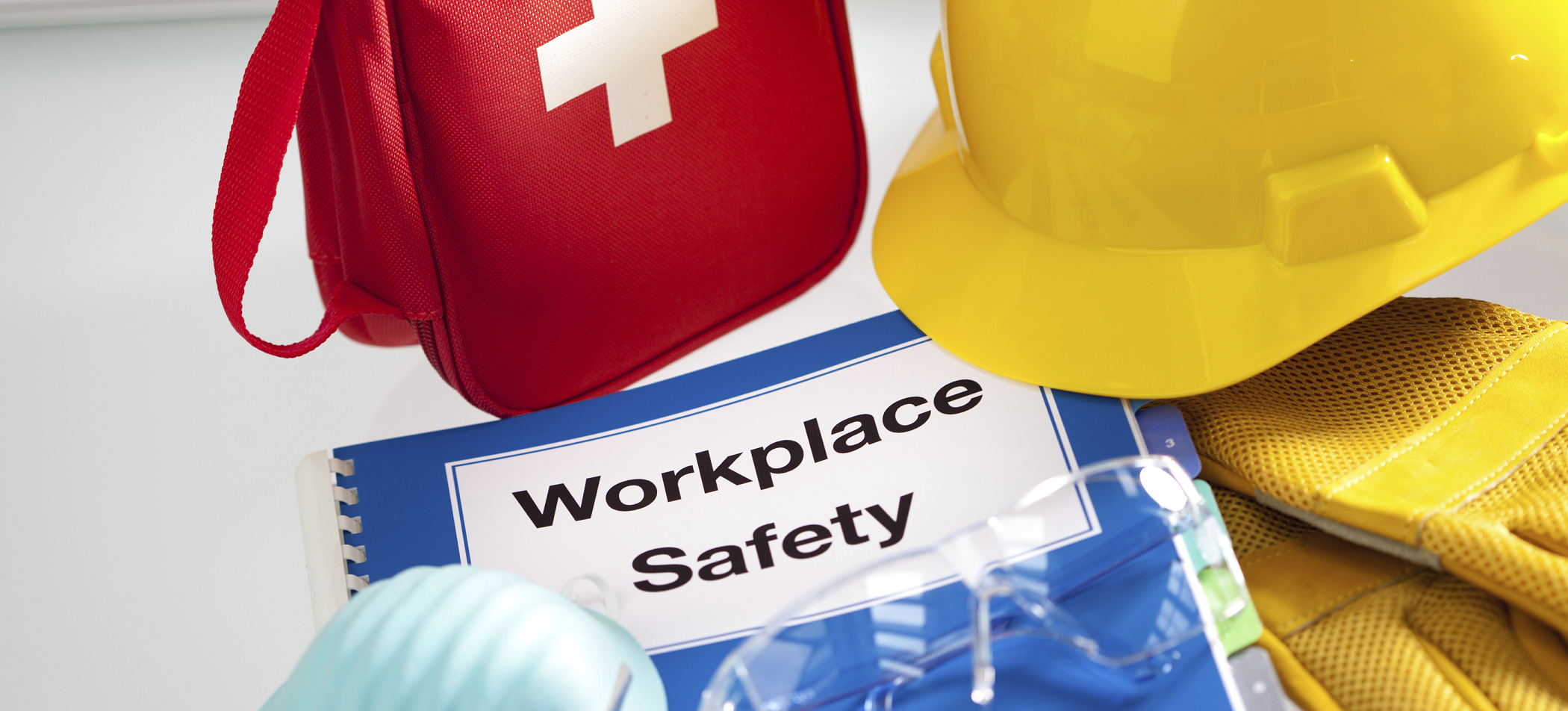 Workplace safety booklet, first aid kit, hard hat, gloves and mask - safety solutions